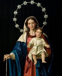 La Virgen porta el rosario en su mano derecha