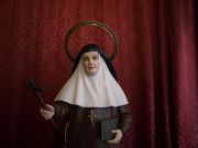 Detalle de los atributos iconográficos, la cruz y el libro, en las manos de la santa